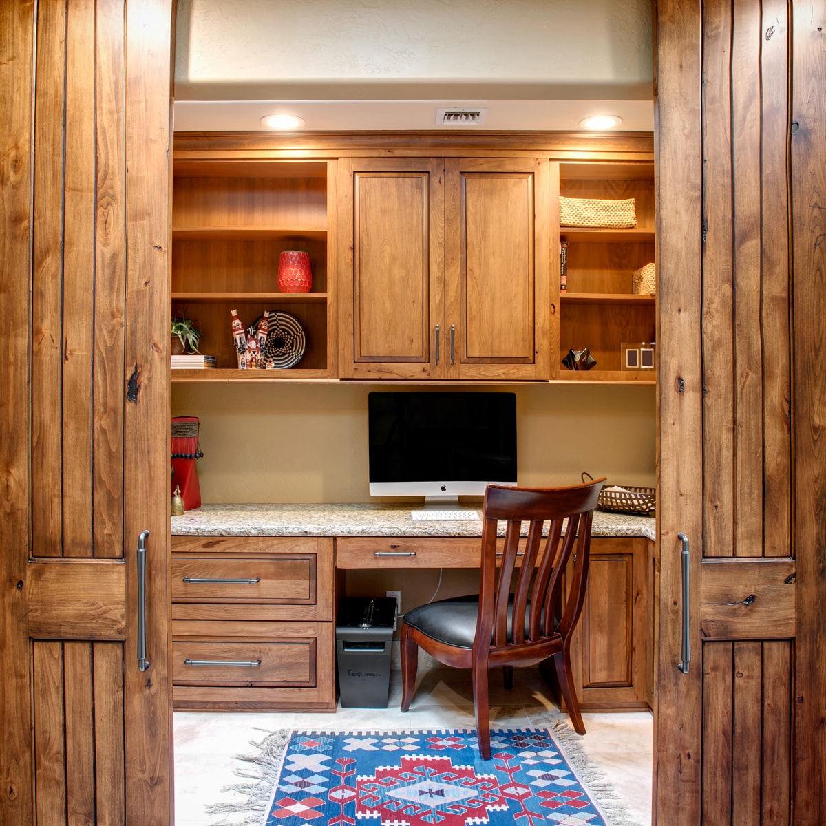 Home office with upper and lower cabinets and barn doors.