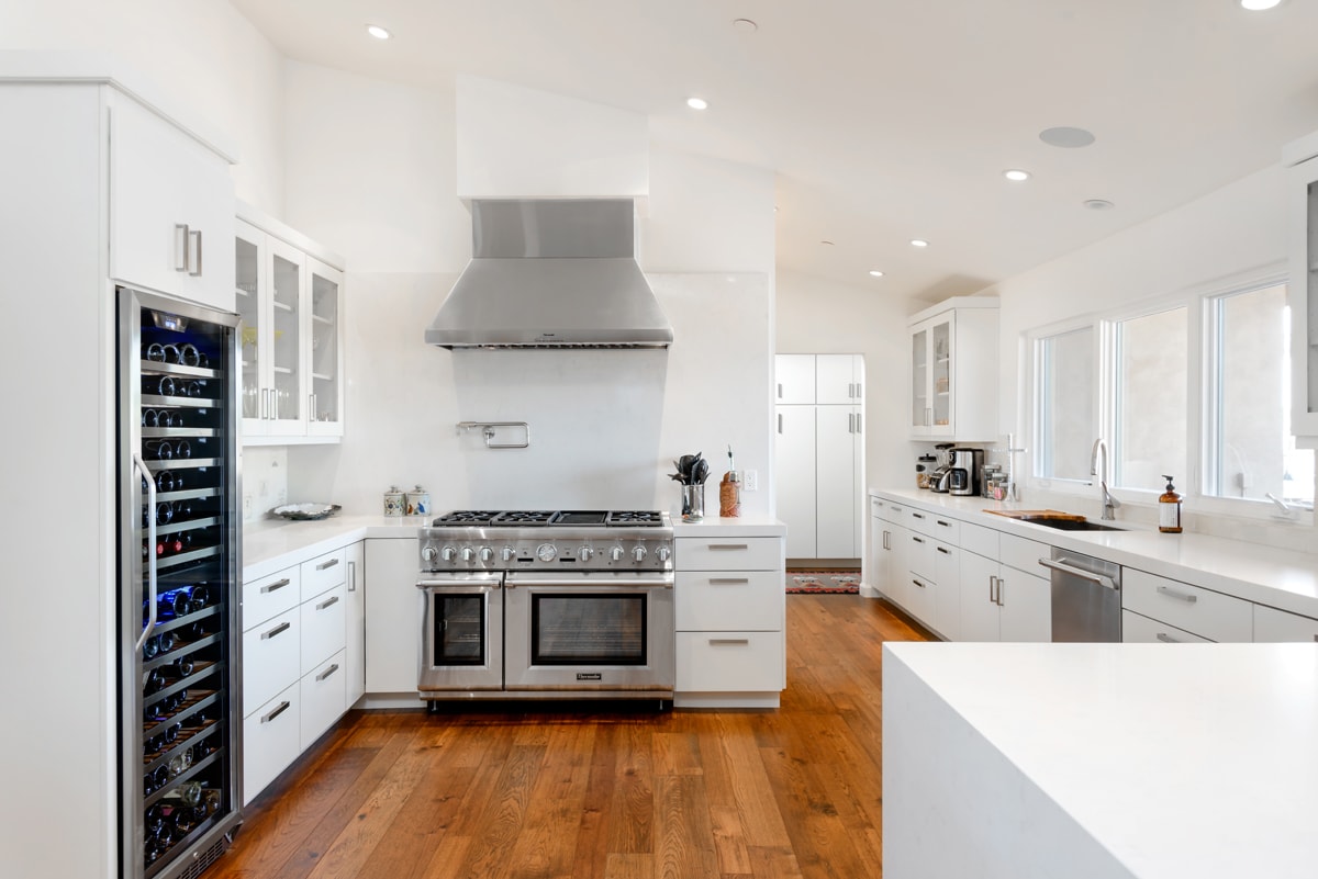 A creatively configured kitchen with tall white cabinetry and a Butler's pantry.