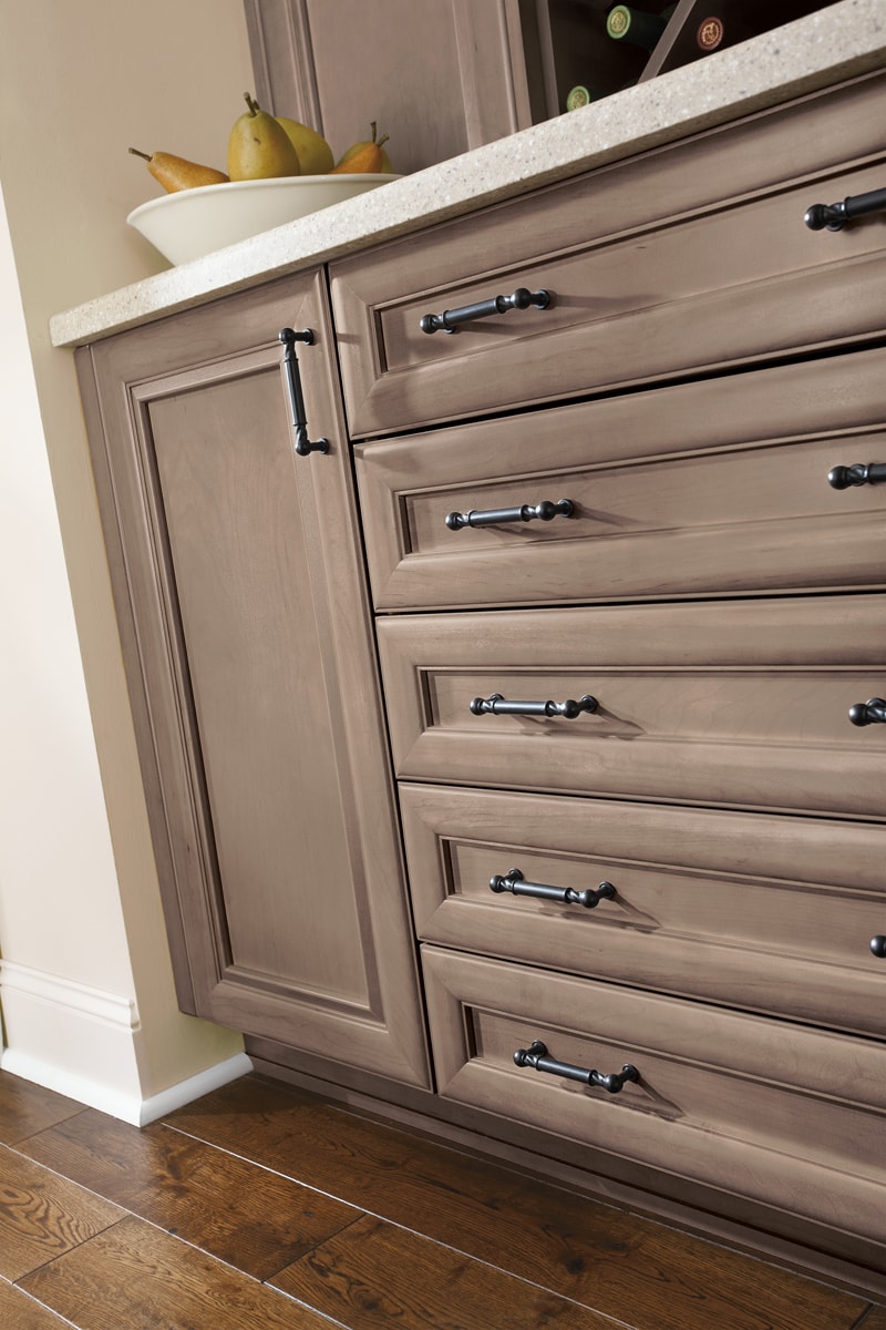 Traditional Style beige cabinets with detailed black hardware.