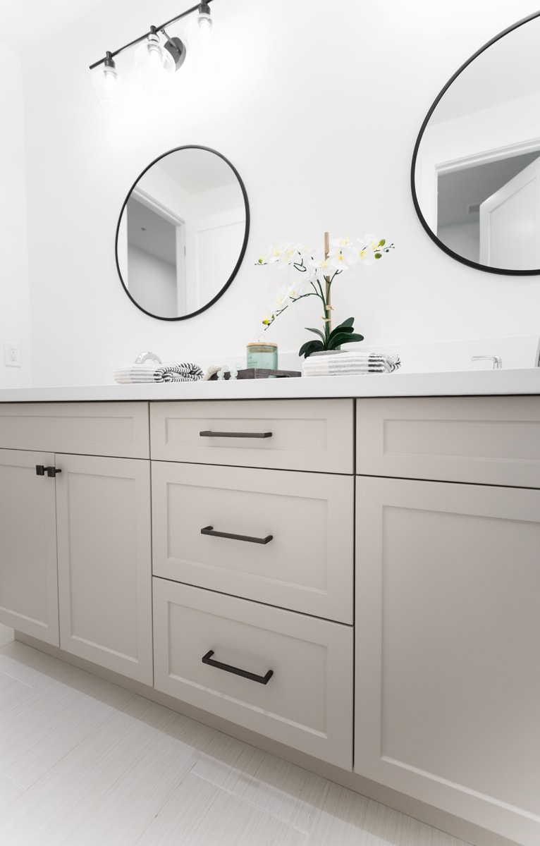 A beige double vanity focusing on the shaker-style cabinet doors.