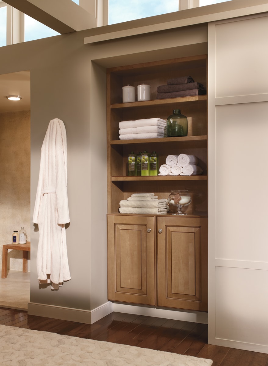 Two cabinets with four shelves on top filled with assorted bath products.