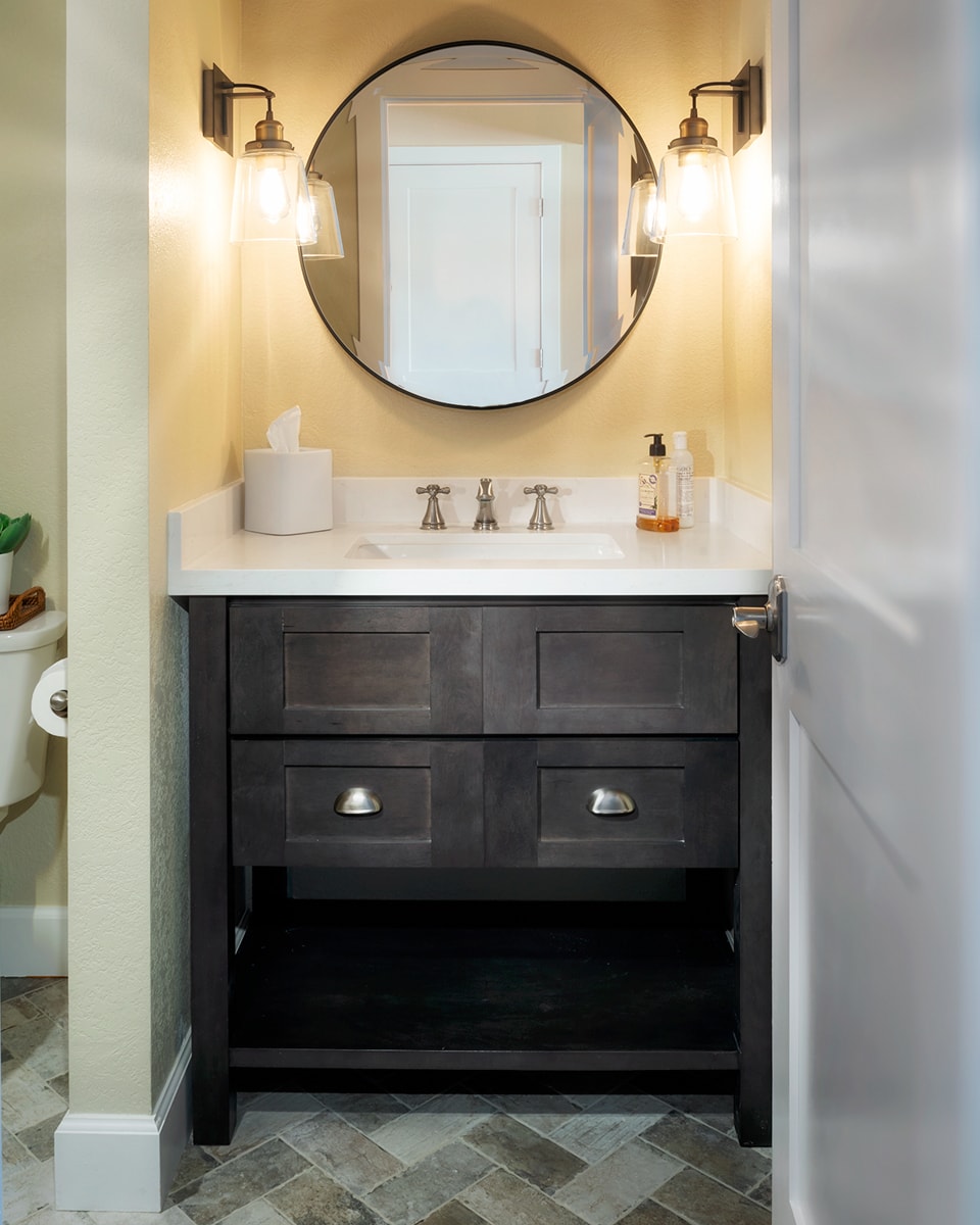 A black vanity fit snugly in a bathroom nook.