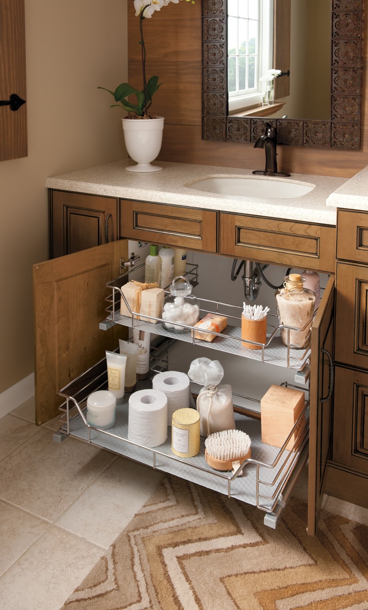 Open vanity bathroom cabinets with two-tier pull-out shelving with bath products.