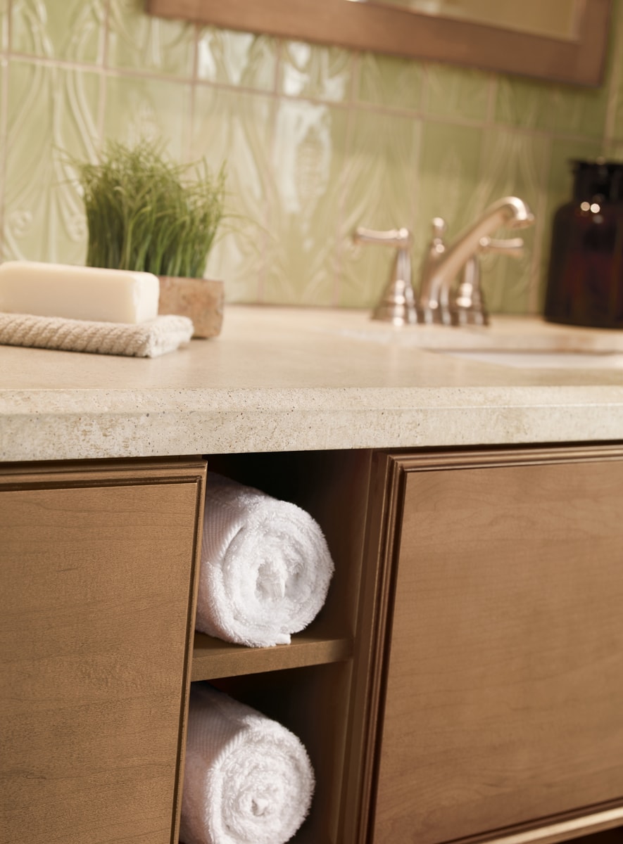 Close-up of a bathroom vanity with two shelves to hold rolled-up towels.