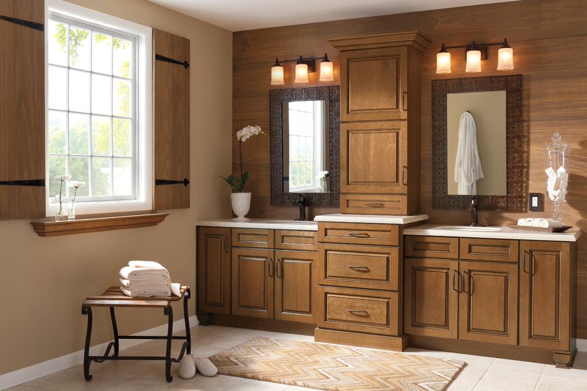 Warm wood double bathroom vanity with cabinets and wood paneling on the wall.