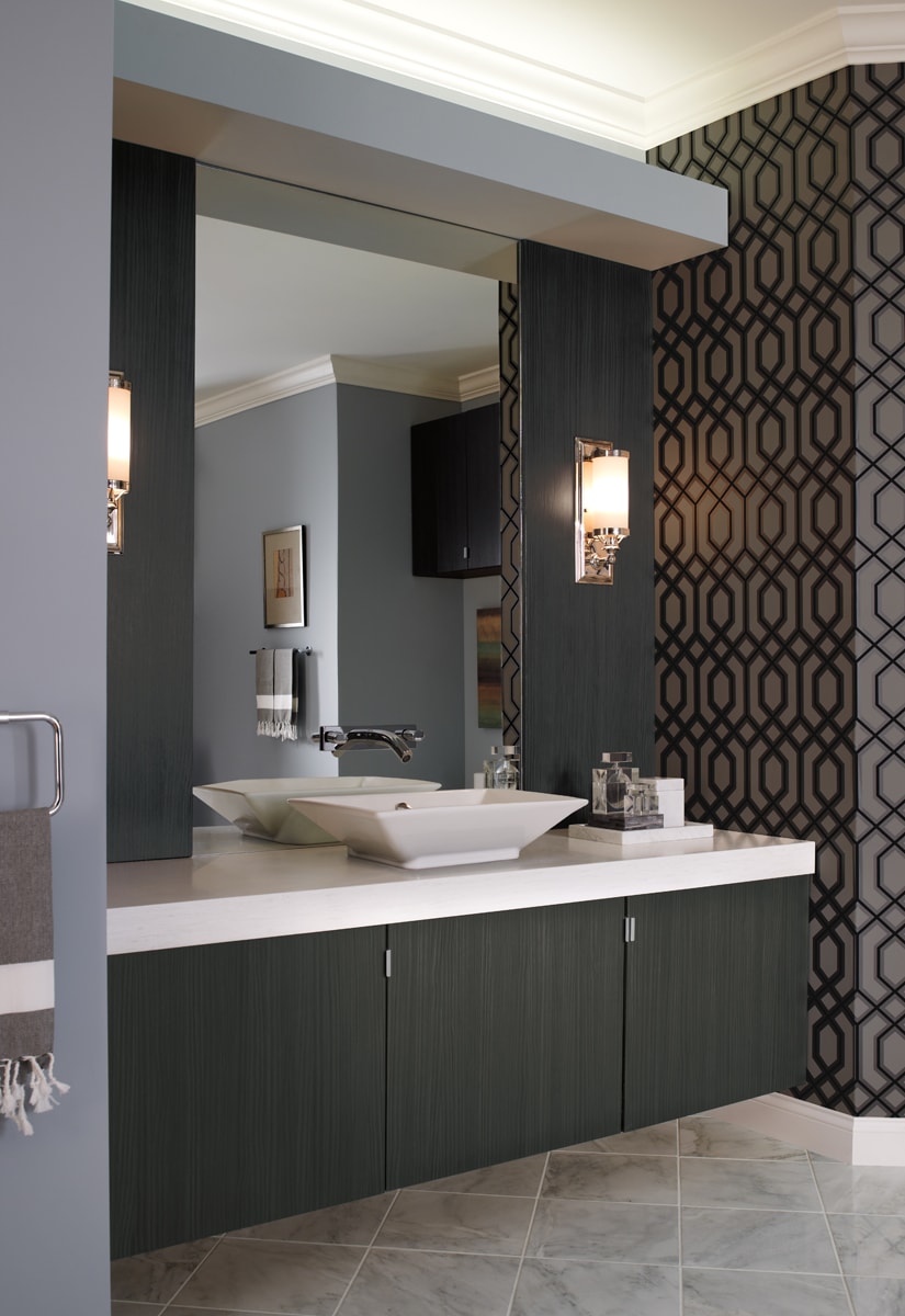 Black floating bathroom vanity with a mirror with bold black geometric wallpaper on the adjacent wall.