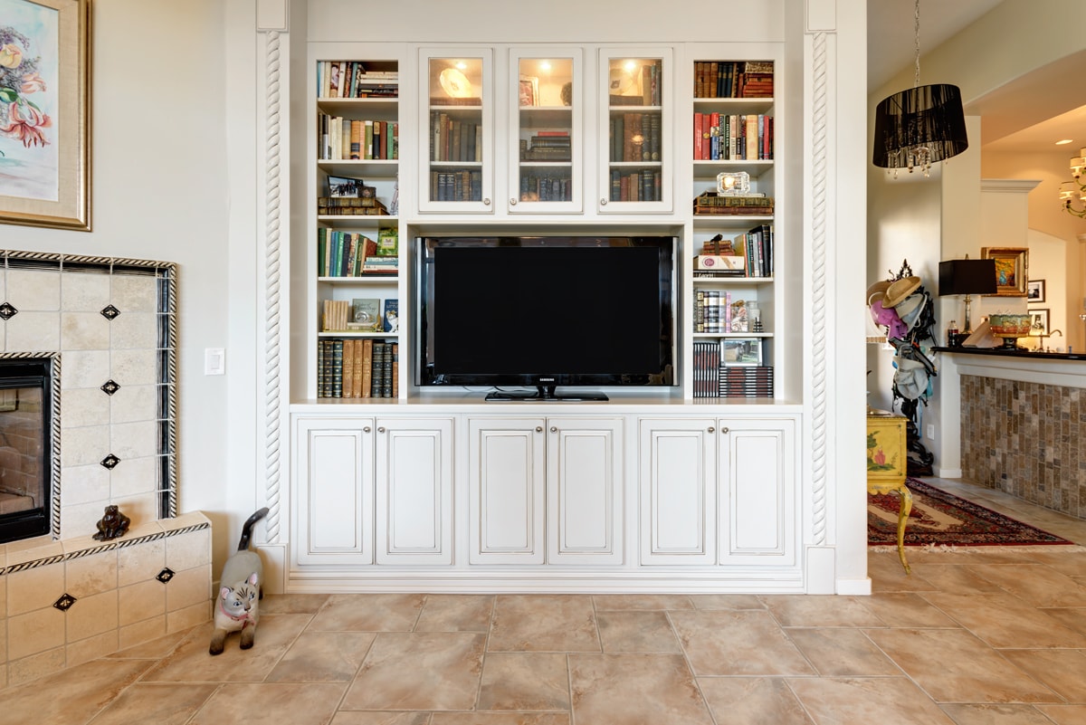 White bookshelf with a combination of open and closed cabinetry.