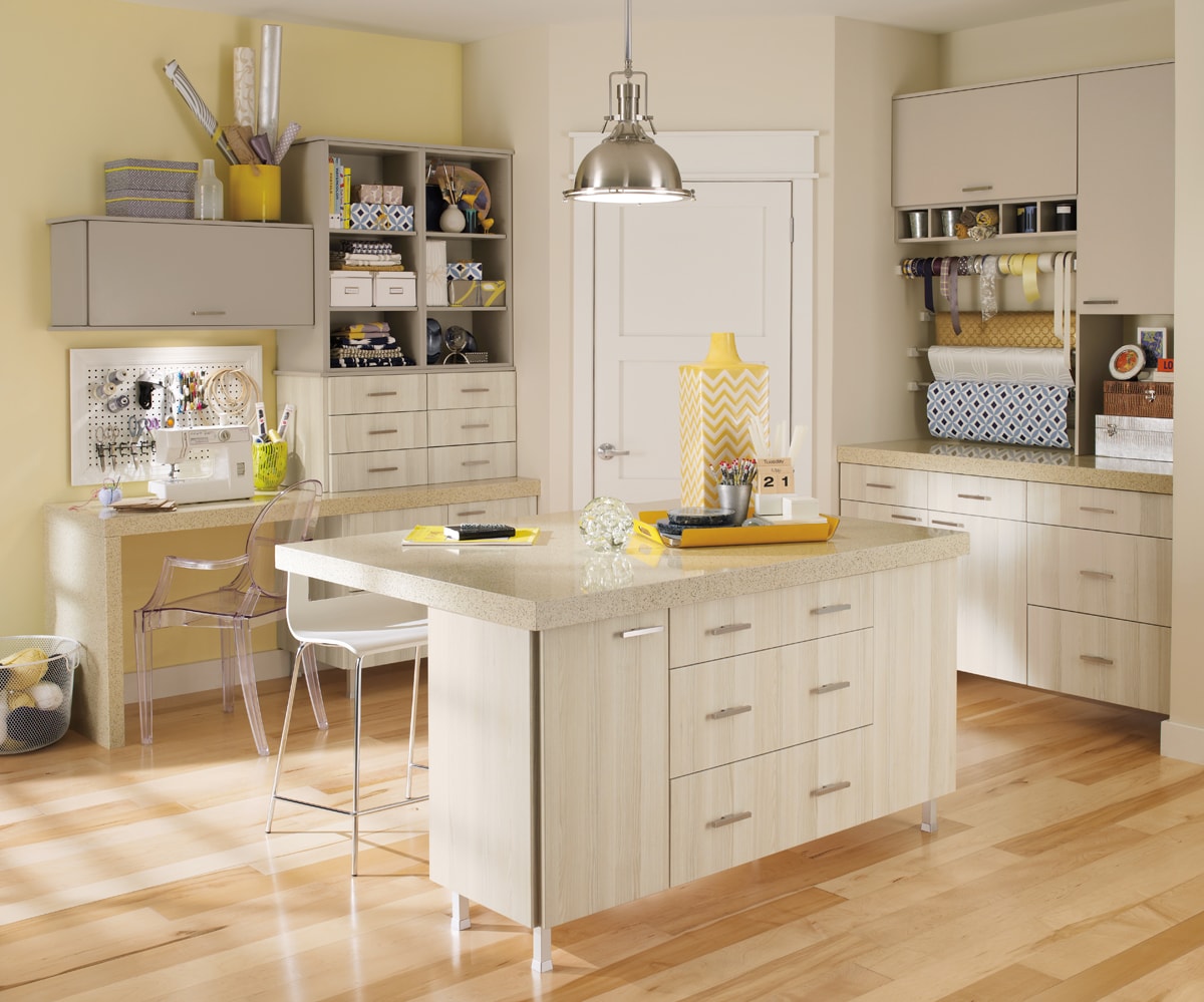 Yellow and beige craft room with beige wall cabinetry.
