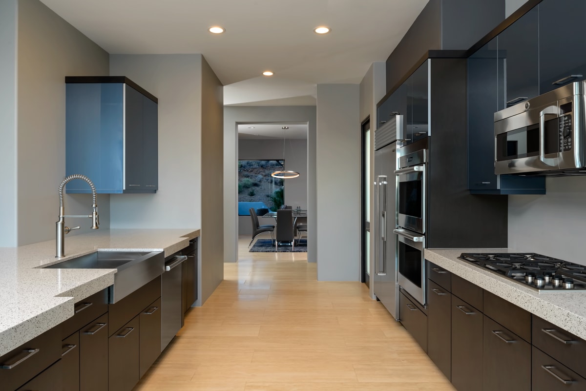Contemporary style kitchen with slab style blue and brown cabinets.