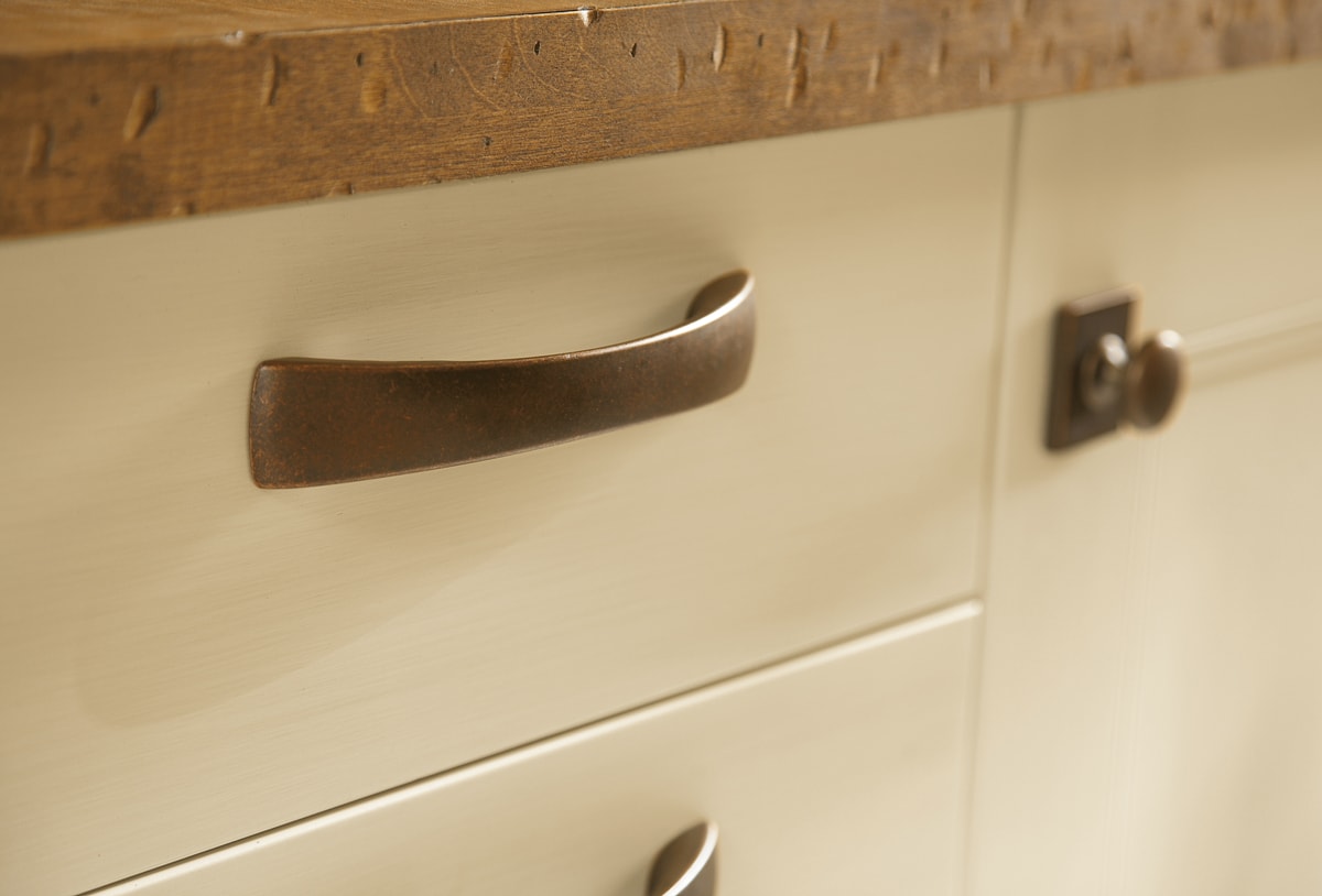 Warm cream cabinet with a distressed hardware pull.