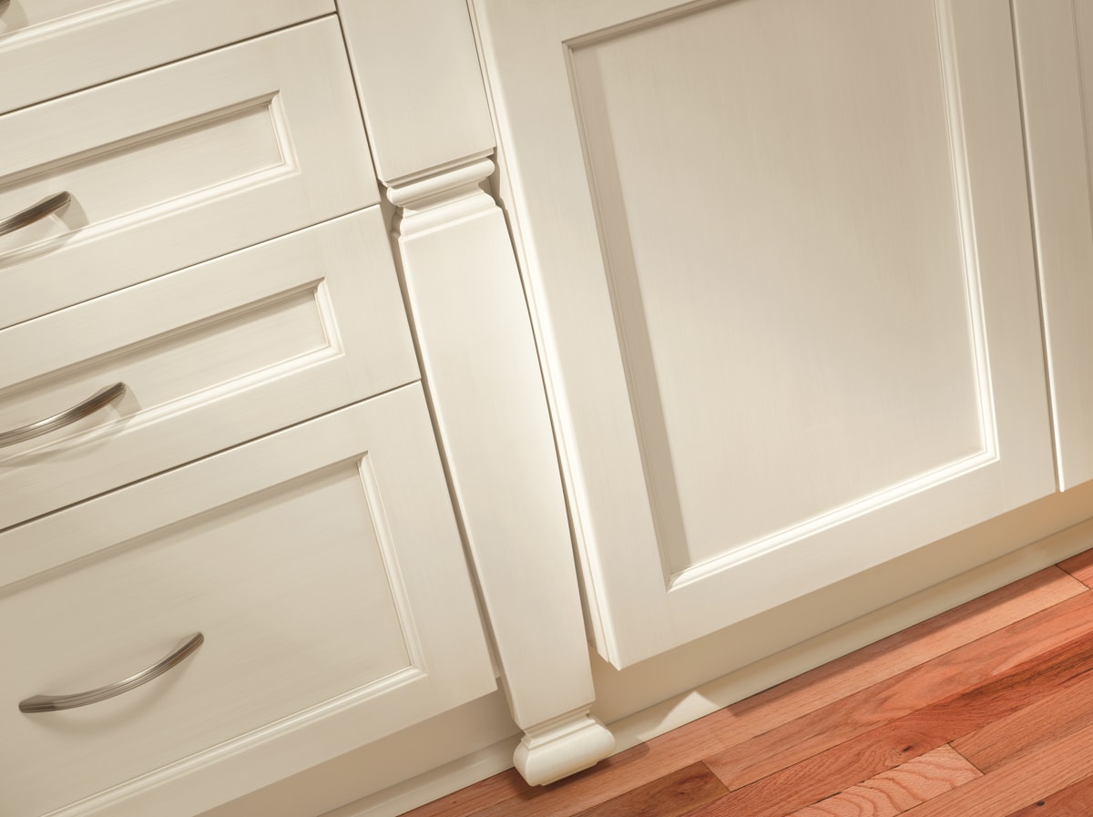 Close up cream kitchen cabinets with intricate design details.