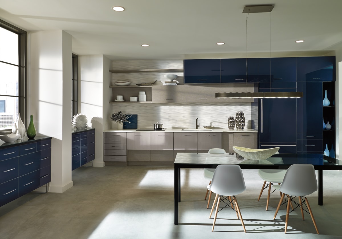 A Contempoary kitchen with a mixture of shiny blue and textured grey cabinets.