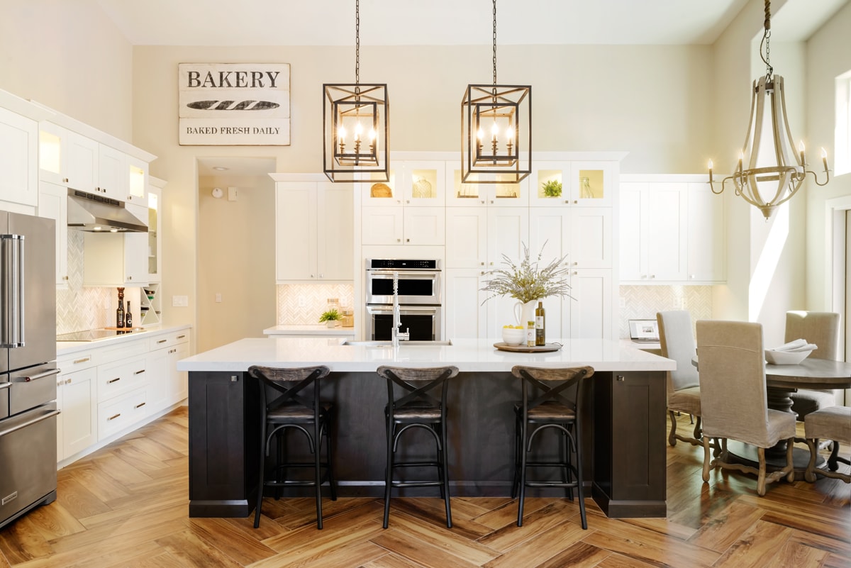 A warm-toned kitchen with white cabinetry and soft lighting.