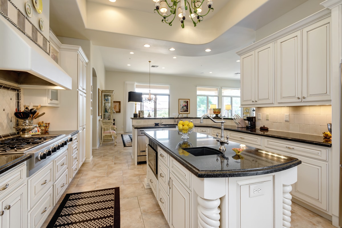A Traditional style kitchen with ornate wood details and detailed white cabinetry.